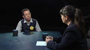 An interview with a man and woman sitting at a table.