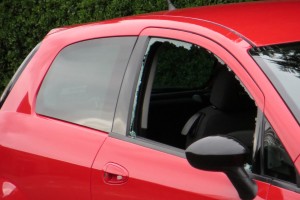 A red car with a broken window.