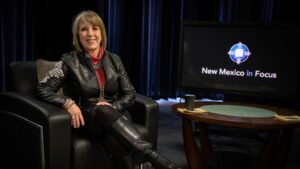 Michelle Lujan Grisham poses for a photo, sitting in a leather chair in the NMIF studio.