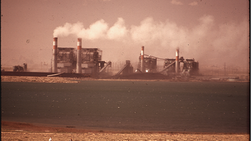 A factory on the coast of a body of water.