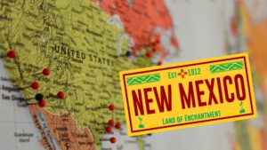 Composite of a United States map, with superimposed banner for New Mexico: Land of Enchantment.