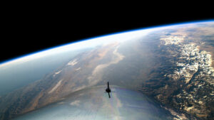 The wing of a Virgin Galatic ship looking over Earth.