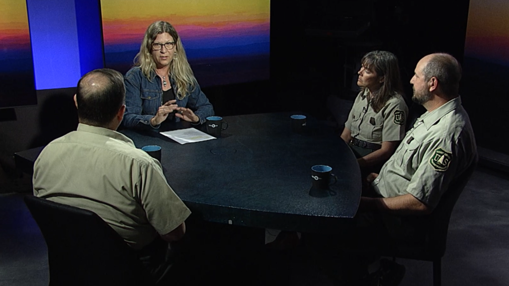 A group of people sitting around a table in an interview.