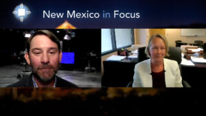 Two people engaged in a virtual conversation with the text "New Mexico in Focus" displayed at the top. One person is in a studio, and the other is in an office setting.