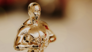 A close-up of a golden statuette resembling an iconic film award, with a blurred background.