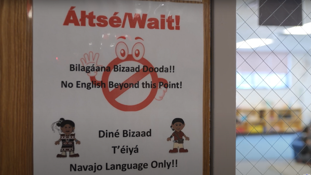 Sign on door stating, "No English Beyond this Point!" in English and Navajo, with illustrations of two characters and a no-entry symbol.