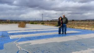 A couple stands at the site of their former home.